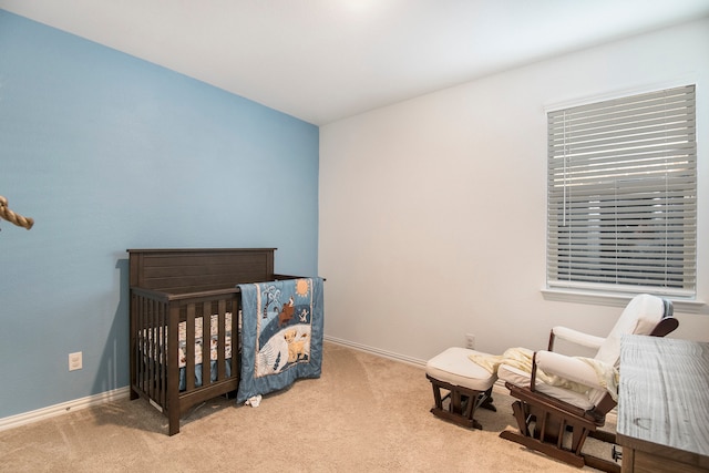 bedroom featuring light carpet and a nursery area