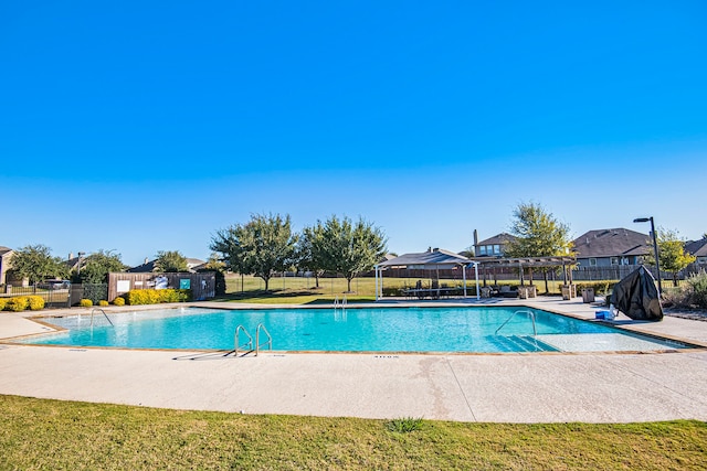 view of swimming pool with a patio area and a yard