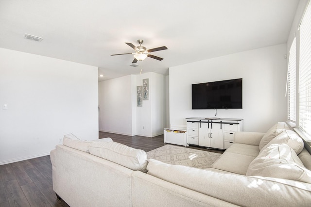 living room with ceiling fan and dark wood-type flooring