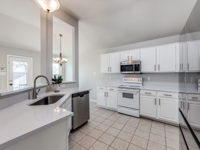 kitchen with light tile patterned flooring, sink, appliances with stainless steel finishes, pendant lighting, and white cabinets