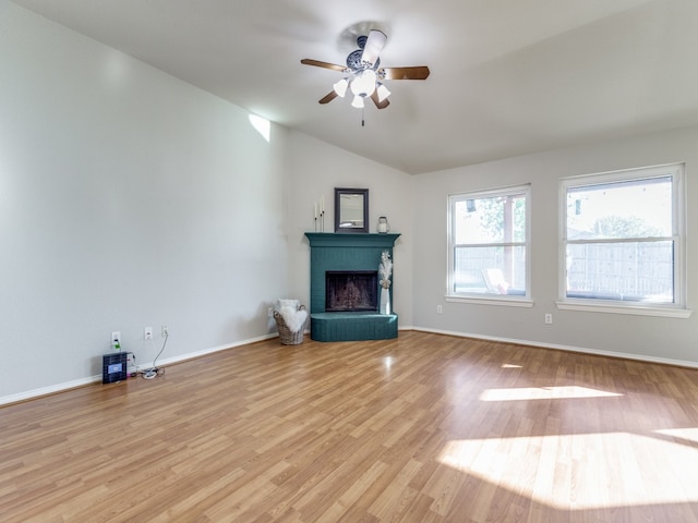 unfurnished living room with vaulted ceiling, ceiling fan, a fireplace, and light hardwood / wood-style floors