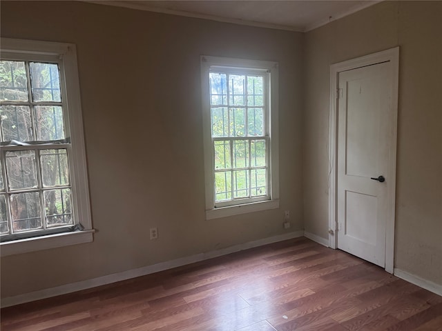 unfurnished room featuring hardwood / wood-style floors, plenty of natural light, and crown molding