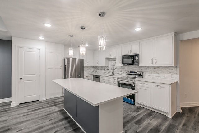 kitchen featuring tasteful backsplash, a center island, appliances with stainless steel finishes, pendant lighting, and white cabinets