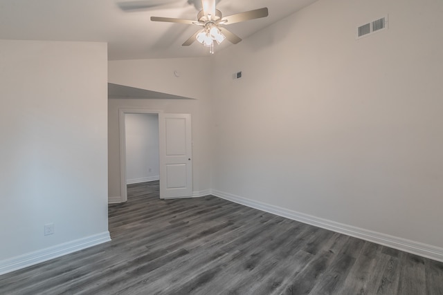 empty room with lofted ceiling, dark hardwood / wood-style flooring, and ceiling fan