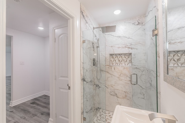 bathroom with a shower with shower door and wood-type flooring