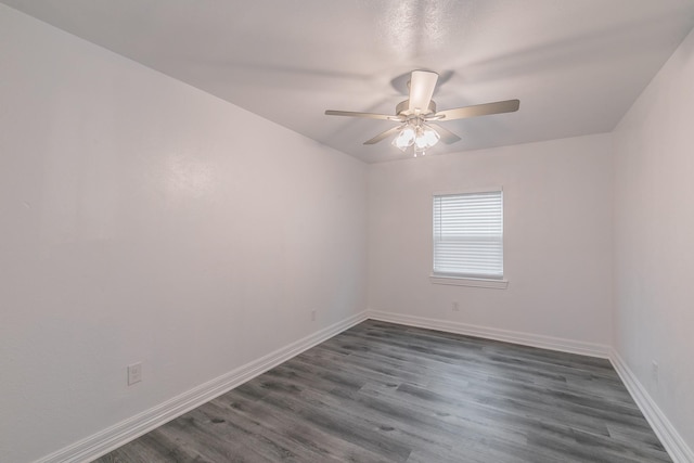 spare room with dark hardwood / wood-style flooring and ceiling fan