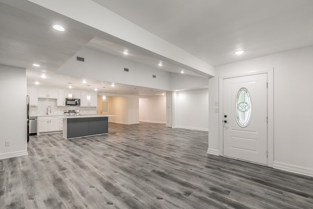 foyer featuring lofted ceiling, dark hardwood / wood-style flooring, and sink