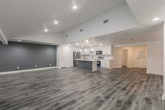 unfurnished living room featuring wood-type flooring, sink, and high vaulted ceiling