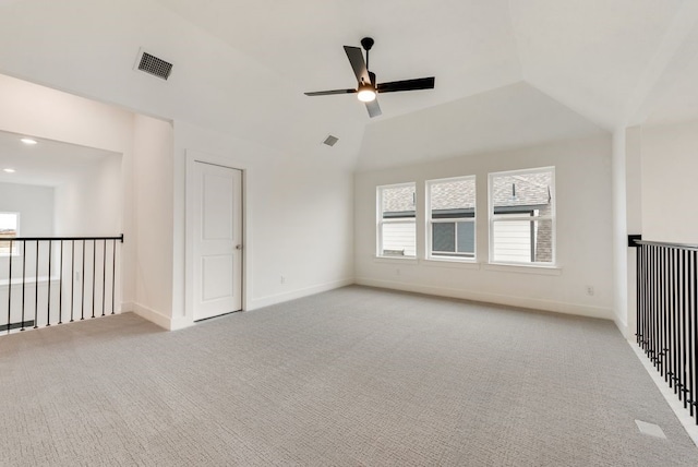 carpeted spare room with ceiling fan and vaulted ceiling