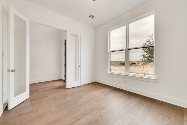 spare room with french doors and light wood-type flooring