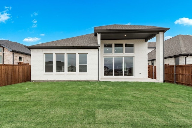 rear view of house with a patio and a lawn