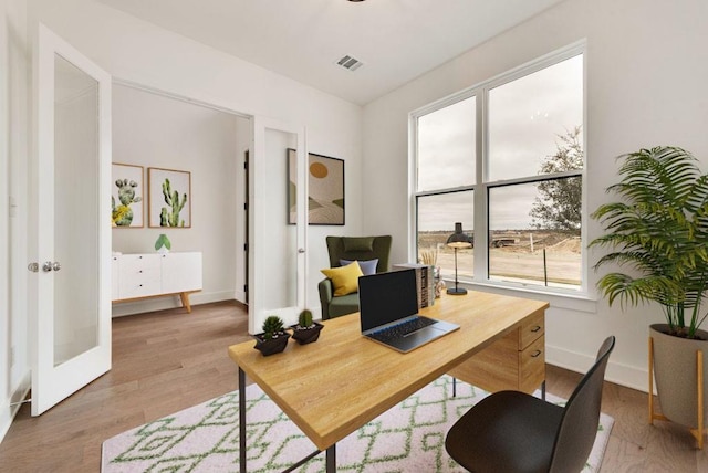 home office featuring french doors and light hardwood / wood-style floors