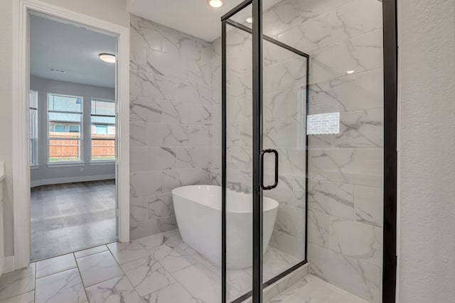 bathroom with tile walls and shower with separate bathtub