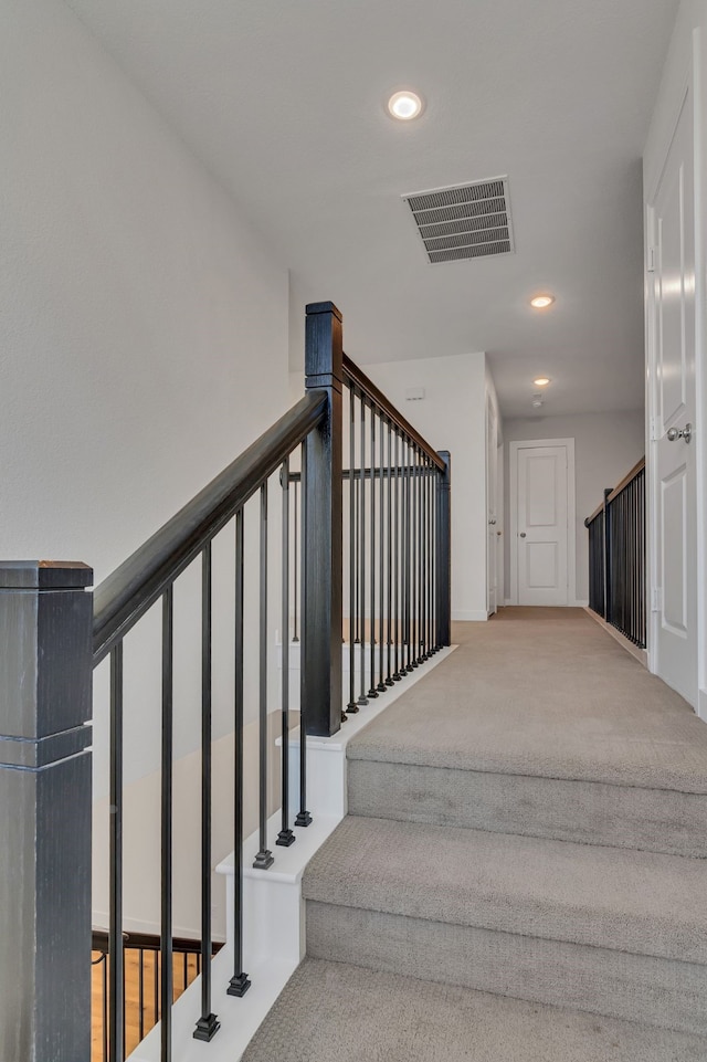 stairs featuring carpet flooring