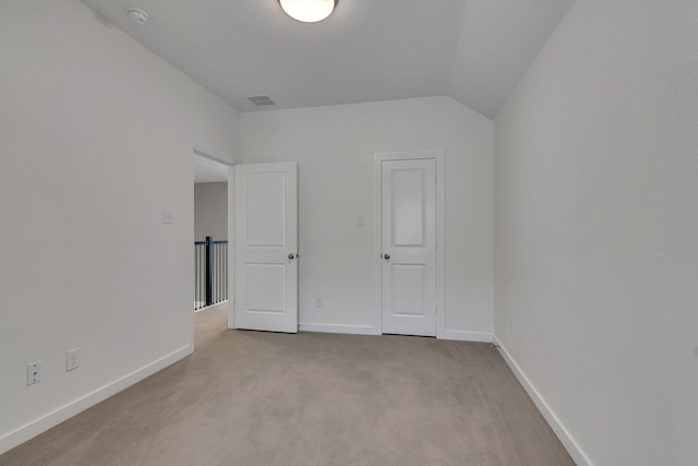 unfurnished bedroom with lofted ceiling and light carpet