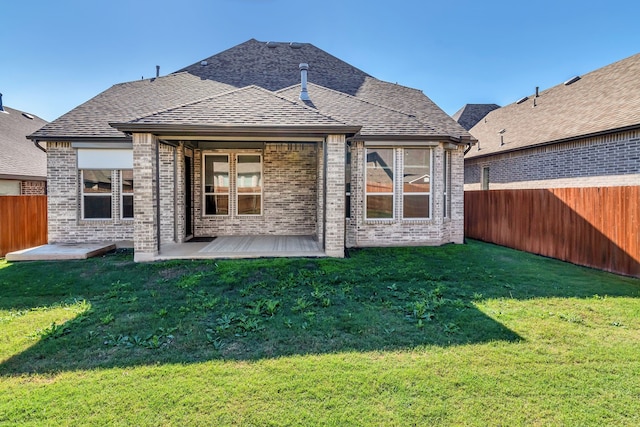 rear view of property featuring a lawn and a patio