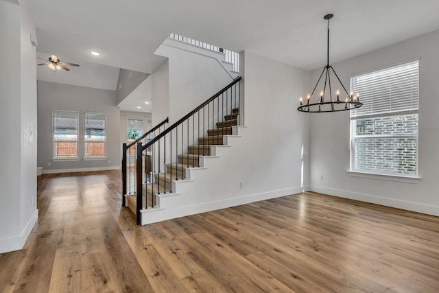 interior space featuring ceiling fan with notable chandelier and hardwood / wood-style flooring