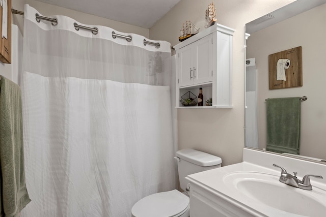 bathroom with walk in shower, vanity, and toilet