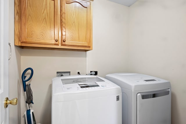 washroom featuring cabinets and washing machine and clothes dryer