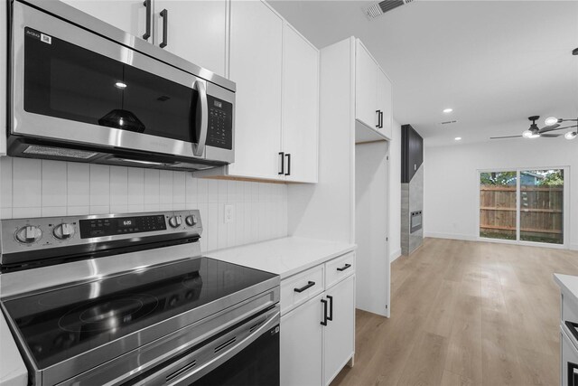 kitchen with white cabinetry, appliances with stainless steel finishes, light hardwood / wood-style floors, and tasteful backsplash