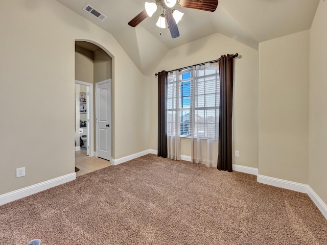 empty room featuring light carpet, vaulted ceiling, and ceiling fan