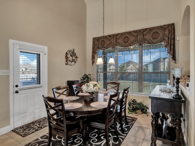 dining room with light tile patterned flooring and a high ceiling