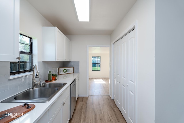 kitchen featuring white cabinetry, stainless steel dishwasher, sink, and tasteful backsplash