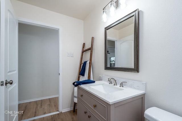 bathroom with wood-type flooring, toilet, and vanity