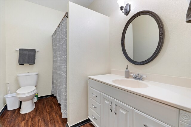 bathroom featuring wood-type flooring, toilet, and vanity