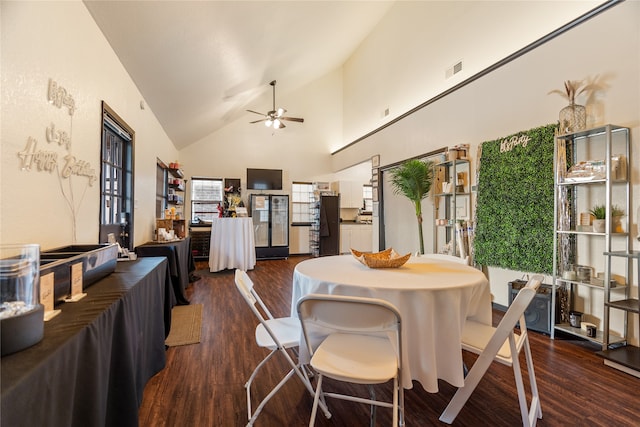 dining room with ceiling fan, high vaulted ceiling, and dark hardwood / wood-style flooring