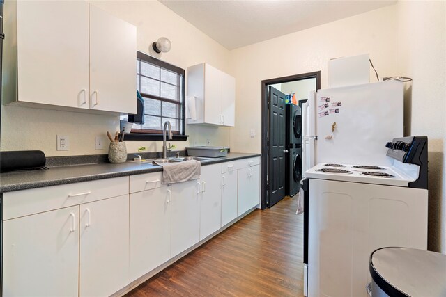 kitchen with stacked washer / dryer, white cabinetry, sink, and white appliances