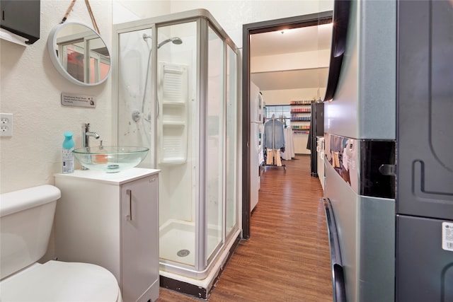 bathroom with walk in shower, wood-type flooring, toilet, and vanity