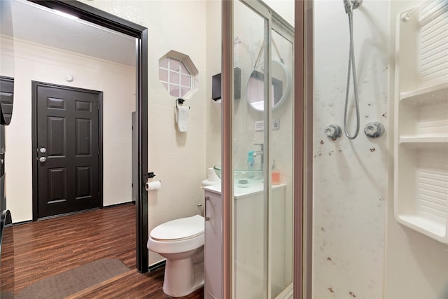 bathroom featuring hardwood / wood-style flooring, toilet, vanity, and walk in shower