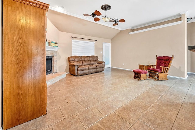 living area with a brick fireplace, lofted ceiling, ceiling fan, crown molding, and light tile patterned flooring