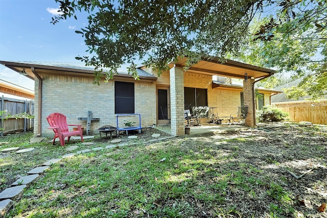 rear view of house featuring a yard and a patio area