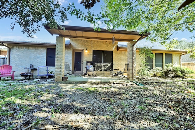 back of property with a patio area and an outdoor fire pit