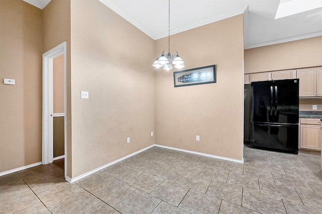 kitchen featuring crown molding, black refrigerator, pendant lighting, and an inviting chandelier