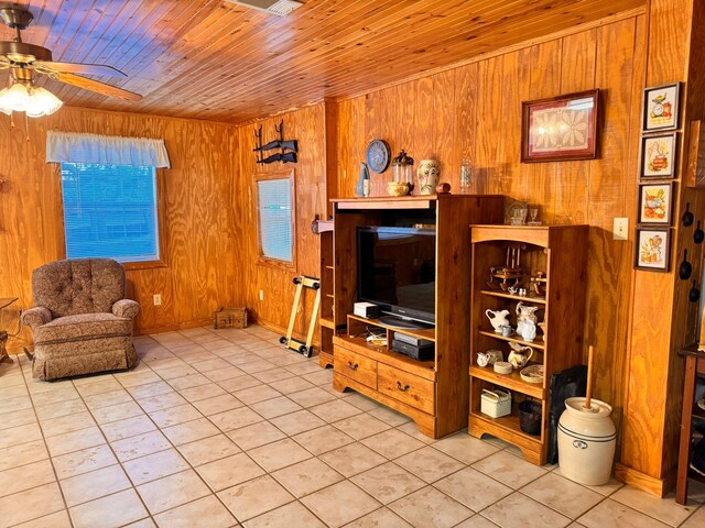 tiled living room featuring wooden ceiling, ceiling fan, and wood walls