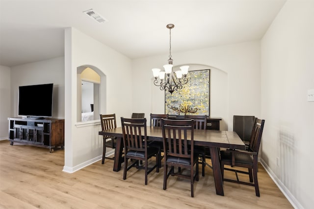 dining area featuring light hardwood / wood-style floors and a chandelier