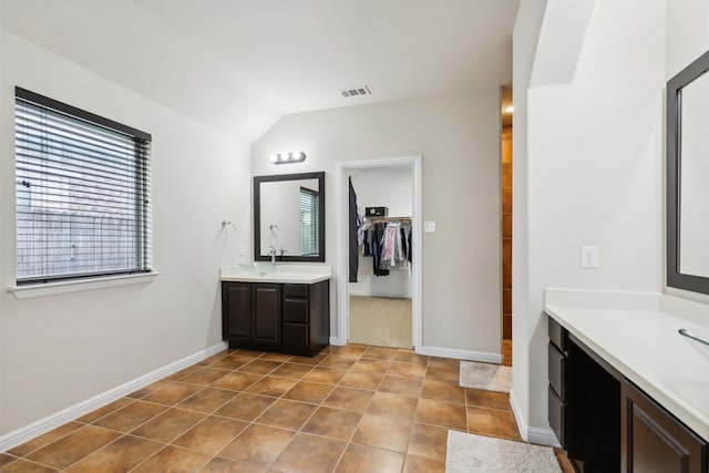 bathroom with vanity, vaulted ceiling, and tile patterned floors