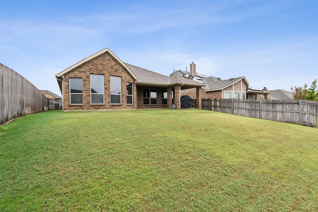 rear view of property with a lawn