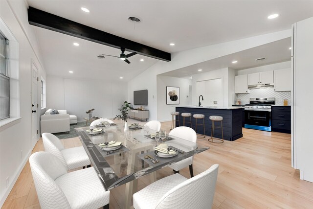 living room featuring ceiling fan, light hardwood / wood-style flooring, lofted ceiling with beams, and sink