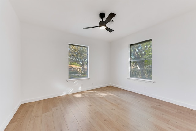 empty room featuring baseboards, ceiling fan, and light wood finished floors