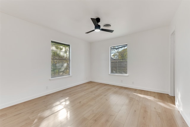 unfurnished room featuring a ceiling fan, baseboards, visible vents, and light wood finished floors