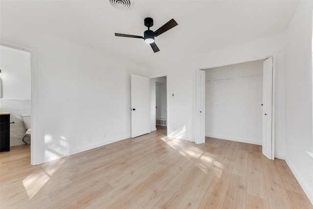 unfurnished bedroom featuring connected bathroom, visible vents, baseboards, a closet, and light wood-type flooring