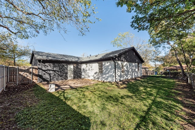 back of house with a fenced backyard, a lawn, and a patio