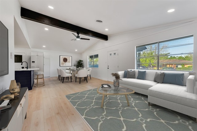 living area with visible vents, a ceiling fan, light wood-style flooring, vaulted ceiling with beams, and recessed lighting