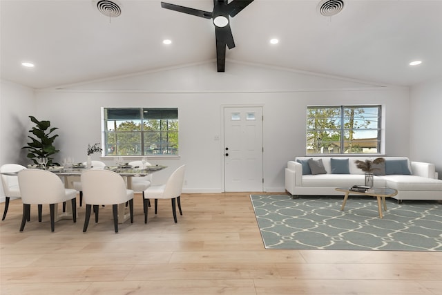 living room with vaulted ceiling with beams, ceiling fan, and light wood-type flooring