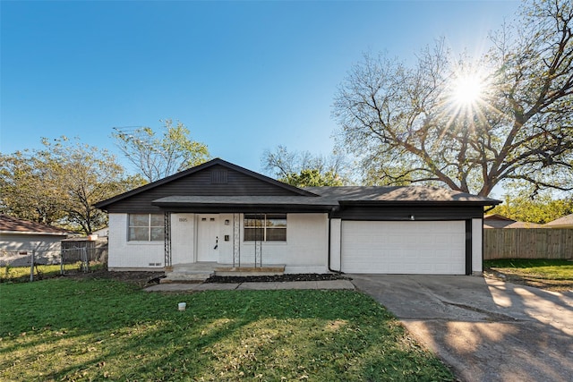 view of front of house with a front lawn, concrete driveway, fence, and an attached garage