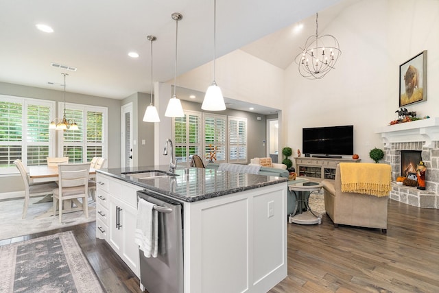 kitchen with white cabinetry, sink, dark hardwood / wood-style floors, pendant lighting, and a fireplace